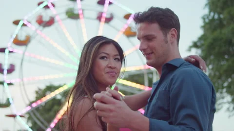 A couple dancing in front of a ferris wheel Stock Footage 55607696