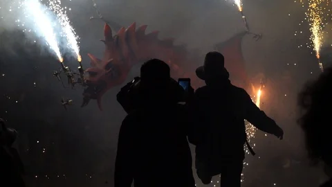 Couple dancing in front of a fire breathing dragon figure Stock-Footage 128403332