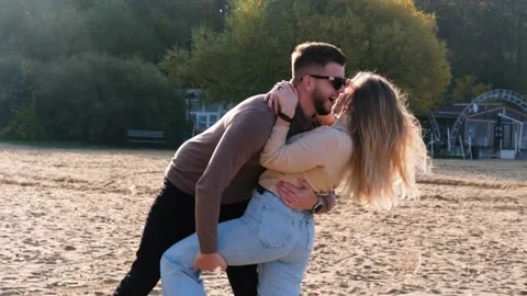 The couple is dancing, having fun and fooling around on the beach. Stock Footage 222780399