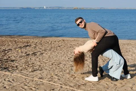 The couple is dancing, having fun and fooling around on the beach. A young be Stock-Fotos