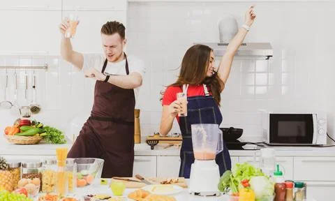Couple dancing in kitchen at table Stock Photos
