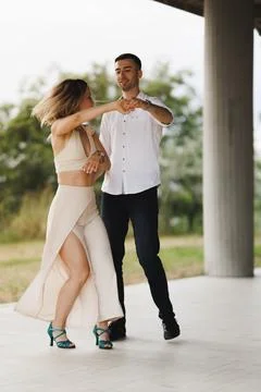 Couple dancing outdoors practicing a romantic Latin partner dance under a Stock Photos