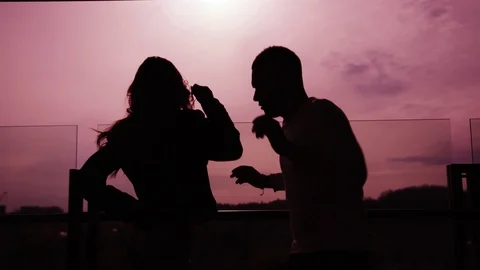 Couple dancing passionately on the rooftop at sunset sky background. Happiness Video stock 112674121