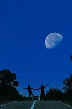 Couple dancing on the road under the moon Stock Photos