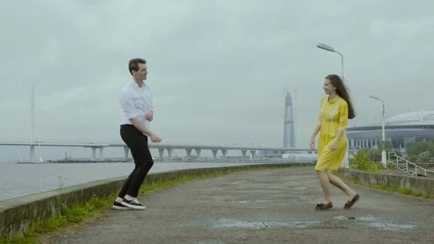 Couple dancing rock-n-roll dance together at the embankment after the rain. Stock Footage 80670101