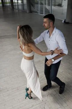 Couple dancing salsa in a modern hall practicing partner dance steps Stock Photos