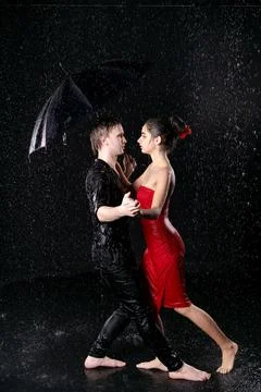 Couple Dancing Under Umbrella in Rain Full Body Shot Stock Photos