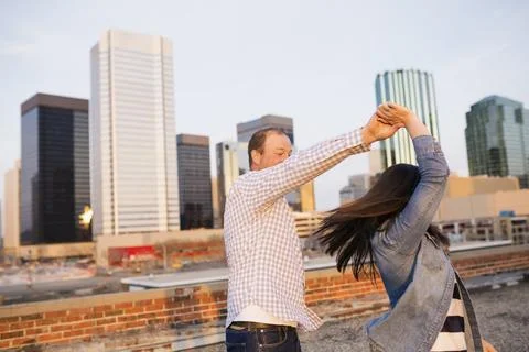 Couple dancing on urban rooftop Stock Photos