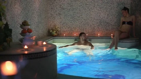 A couple on a date at beautiful swimming pool in sauna Stock Footage 73673729