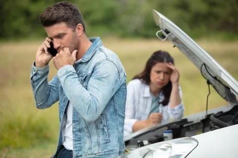 Couple dealing with car breakdown Stock Photos