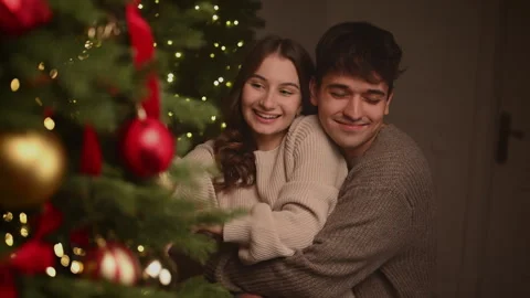 Couple decorating a Christmas tree in a warm festive atmosphere. Vídeo Stock 322670620