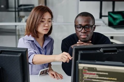 Couple of developers working on computer together Stock Photos