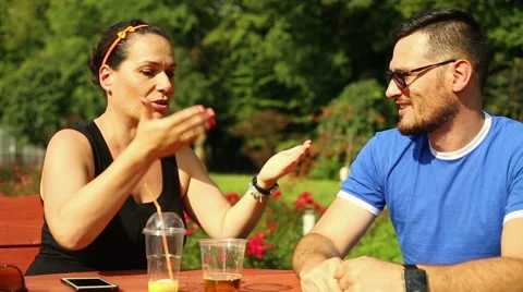 Couple is discussing, sitting at the park Stock Footage 65807645