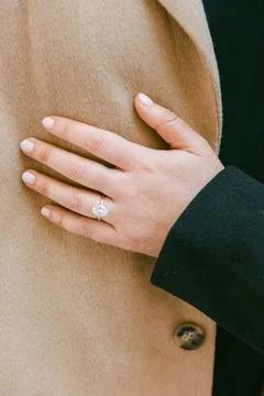 Couple displays engagement ring while embracing outdoors, showcasing love in a Stock Photos