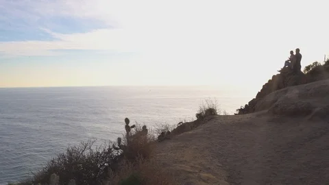 Couple in distance overlooking cliffs, 4k Stock Footage 103437126
