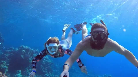 Couple dive deep in blue sea and taking selfie on action camera among coral reef 스톡 동영상 186676832