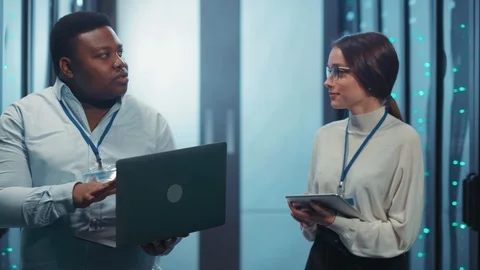 Couple of diverse server specialists talking sharing responsibilities in data Stock Footage 119738013
