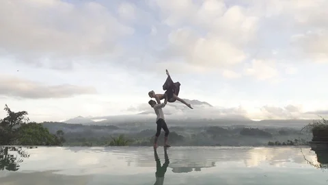 Couple do Stunning Partner Acro Lift On Infiniti Pool Edge Bali Stock Footage 106036898