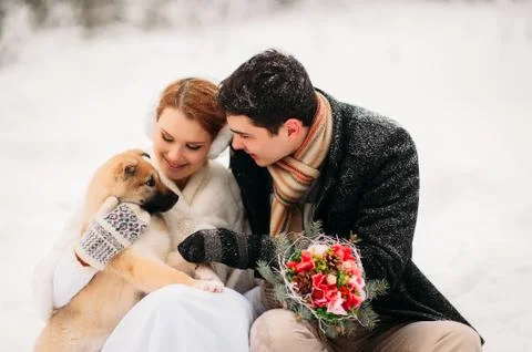 Couple with a dog in winter forest Stock Photos