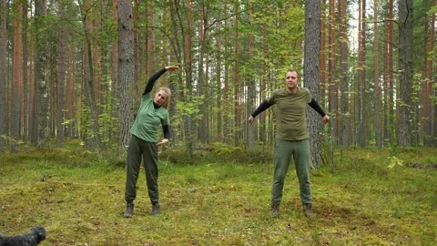 A couple is doing exercises outdoors. Stockbeeldmateriaal 318832644