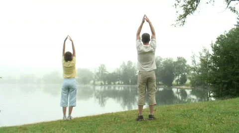 Couple doing gymnastics at a lake Stock Footage