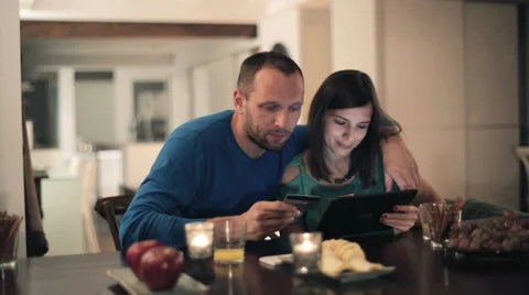 Couple doing online shopping with tablet computer by the table HD Stock Footage 33778351
