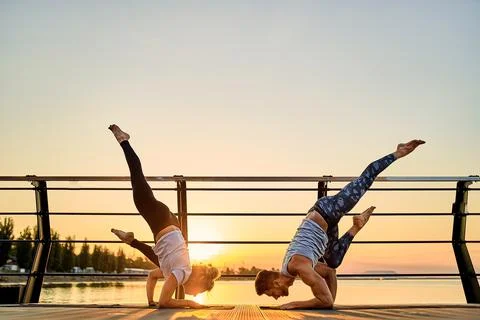 Couple doing practicing yoga together on nature outdoors . Morning exercises at Foto stock