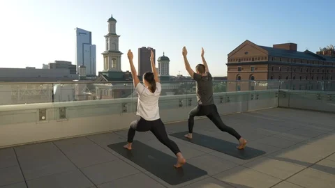 Couple Doing Rooftop Yoga Overlooking Skyline Vídeos de archivo 99060450