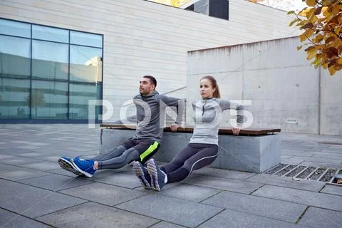 Couple doing triceps dip exercise outdoors Stock Photos