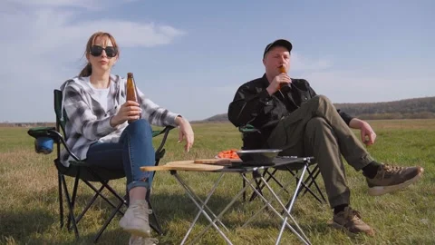 Couple drinking beer and relaxing at a picnic barbecue 库存影片 319791730