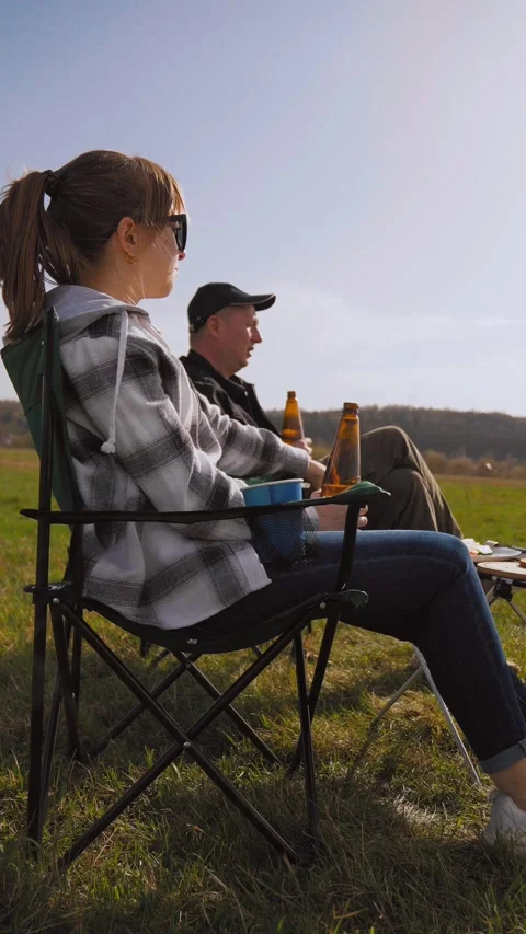 Couple drinking beer and relaxing at a picnic barbecue Видео 319791907
