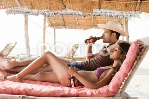 Couple Drinking Beer At Beach