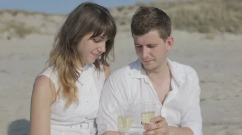 Couple drinking champagne on a beach Stock Footage 61755375