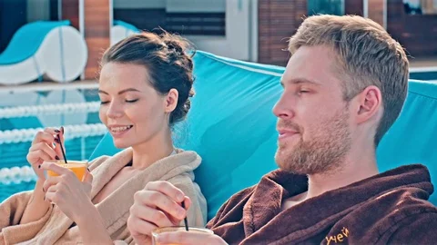 Couple Drinking Cocktails On Deckchairs Stock-Footage 78596024