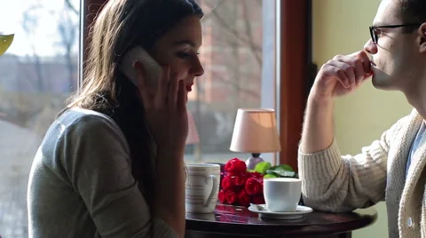 Couple drinking coffee in the cafe and woman talking on cellphone Video stock 48753037