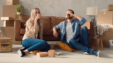Couple Drinking Coffee at Home. Couple Having Coffee from To Go Cups. Fast Food Stock Footage 217684026