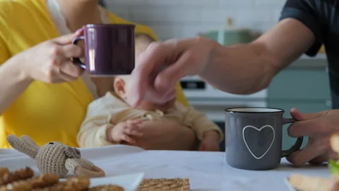 Couple drinking coffee while playing with baby Stock Footage 227370149