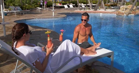 Couple Drinking Poolside, Man and Woman on Tropical Vacation Stock Footage 103220535