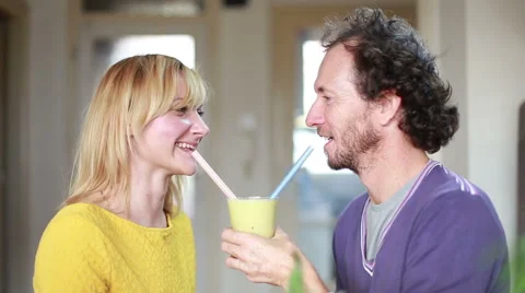 Couple drinking smoothie from same drinking glass Stock Footage 59540637