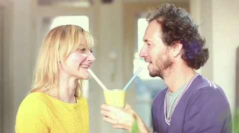 Couple drinking smoothie from same drinking glass Stock Footage 59540640