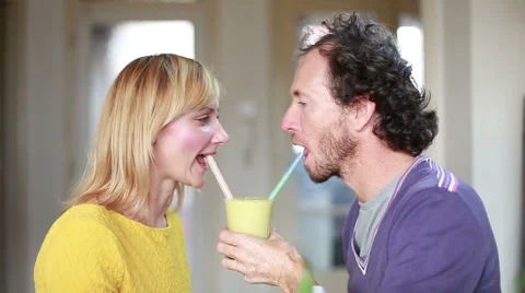 Couple drinking smoothie from same drinking glass Stock Footage 59540645