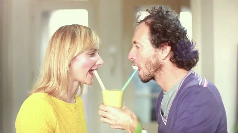 Couple drinking smoothie from same drinking glass Stock Footage 59540649
