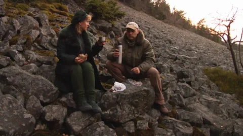 A couple drinking tea from a vacuum flask  on a stone run. Stock-Footage 39805298