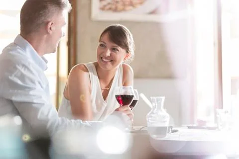 Couple drinking wine and talking at cafe Stock Photos