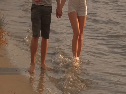 A couple drinking wine and walking down the beach at sunset Stock Footage 80599108