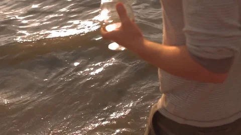 A couple drinking wine and walking down the beach at sunset Stock Footage 80599114