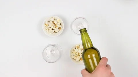 A couple drinks beer and eats popcorn. Woman and a man. Top view Stock Footage 88824158