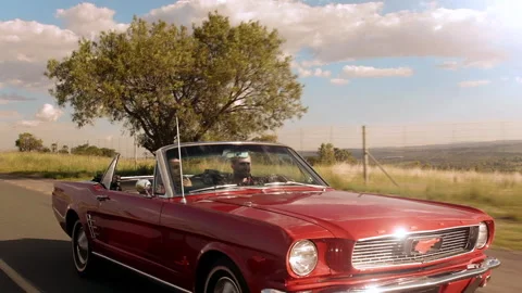 Couple driving classic cherry red convertible, cabriolet car, steadicam shot. Stock Footage 199632067