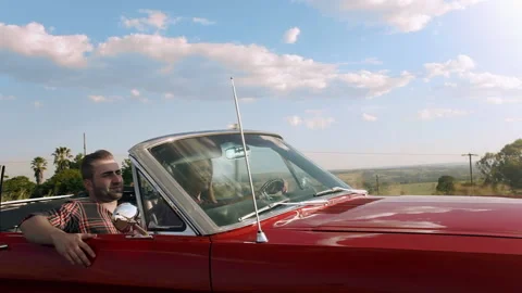 Couple driving classic cherry red convertible, cabriolet car, steadicam shot. Видео 199632074