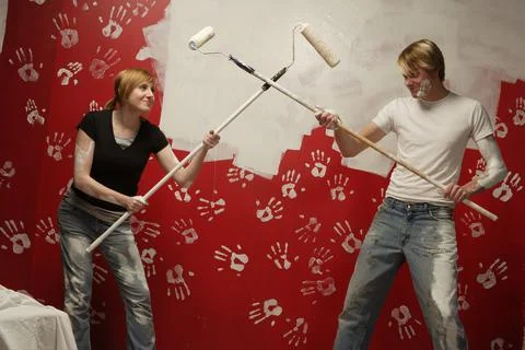 Couple Dueling With Paint Rollers Foto stock